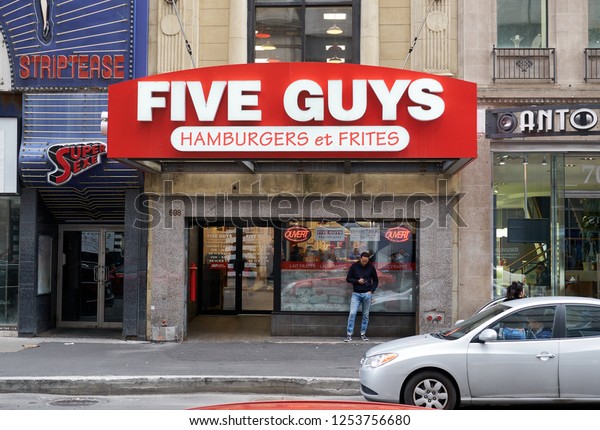 MONTREAL, CANADA -\
OCTOBER 4, 2018: Five Guys street entrance and logo. Five Guys is a\
popular American fast food restaurant focused on hamburgers, hot\
dogs, and French\
fries