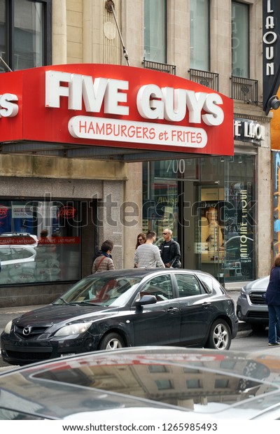 MONTREAL, CANADA -\
OCTOBER 4, 2018: Five Guys street entrance and logo. Five Guys is a\
popular American fast food restaurant focused on hamburgers, hot\
dogs, and French\
fries
