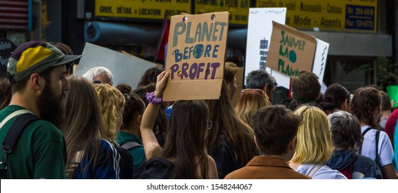 MONTREAL, CANADA - SEPTEMBER 27 2019: Woman Holding "Planet Before Profit" Sign Banner among Huge Crowd Marching for Climate Demonstration School Strike in Downtown