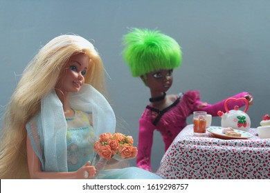 Montreal, Quebec / Canada - January 17 2020: children play a birthday tea party of Barbie doll. She has her anniversary on March 9. Caucasian and Black girl friends have teatime with cookies and cakes