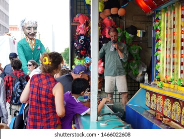 Montreal, Quebec / Canada - July 24, 2019: Excited Kids Play A Water Gun Carnival Game Umder The Owner's Watchful Eyes At Montreal Just For Laughs 2019