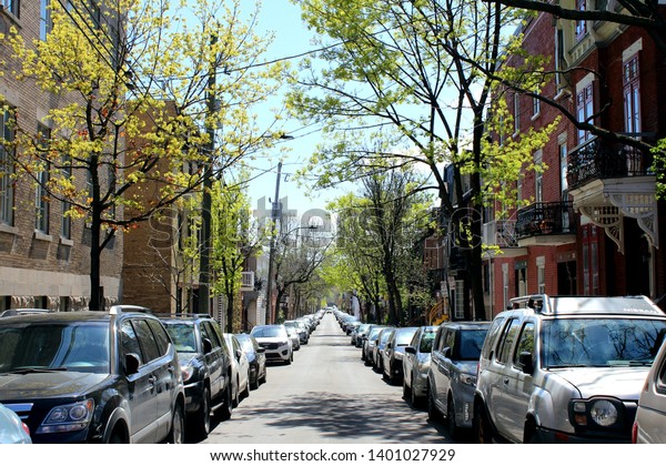 Montreal, Quebec / Canada - May 15 2019: a\
calm and beautiful street in the neighborhood of the Plateau Mont\
Royal with old historical houses and artistic vibes appreciated by\
hipsters and\
millennials
