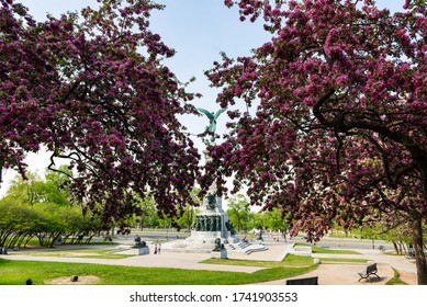 Montreal Quebec Canada May 26 2020: Monument To Sir George-Étienne Cartier In Mount Royal Park, Taken Though Purple Flowering Trees From Behind