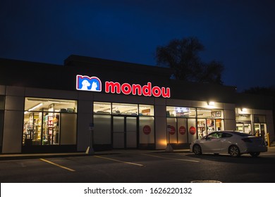 Montreal, Quebec / Canada - October 30 2019: Mondou Pet Store Facade At Night In Ahuntsic Neighborhood With White Car In Parking And Dark Blue Sky In Background