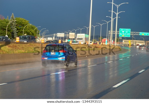 Montreal, Quebec, Canada, September 26, 2018:\
Highway 40 EST Quebec, Canada. Blue car, wet asphalt, thunder sky\
after heavy rain.