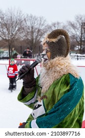 Montreal, Quebec, January 24, 2016 - Referee In Ram Makeup And Disguise With Young Goalie In Front Of Hockey Net In Soft Focus Background During The Montreal Snow Festival In Jean-Drapeau Park