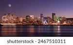 Montreal skyline illuminated at dusk and reflected in St. Lawrence River, Quebec, Canada