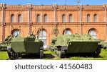 The monument - a fighting machine on a background of blue sky and red building