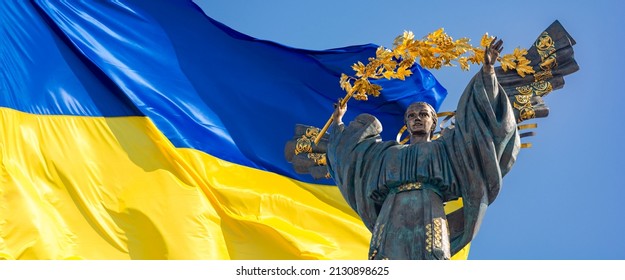 Monument of Independence of Ukraine in front of the Ukrainian flag. The monument is located in the center of Kiev on Independence Square. Russian war in Ukraine. Stop War.