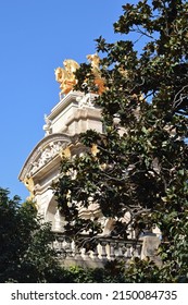 Monument On Stone Plinth With Golden Chariot In Trees