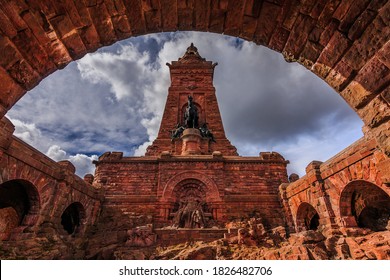 The Kyffhäuser Monument on a sunny day with clouds and blue sky. Bricks in the arch and stones with a statue in Thuringia and southern Harz. Historic building of Kaiser Wilhelm