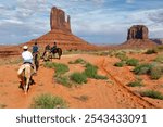 Monument Valley Horseback Riding First person view from the horse with beautiful  sky over the three sisters 