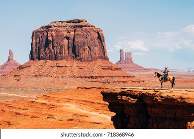 MONUMENT VALLEY, UTAH. 25th, August 2017: a cowboy riding horse with buttes at background