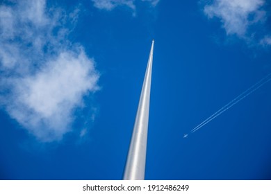 A Monumental Large Needle Seems About To Be Ramming By An Airplane In The Clouds (Spinner In Dublin)