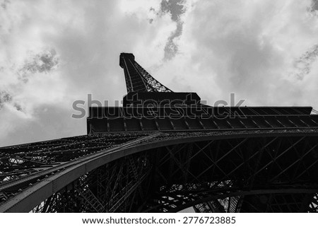 A monumental fine‑art perspective of the Eiffel Tower’s base, emphasizing mass, depth and the sculptural presence of its iron architecture.

