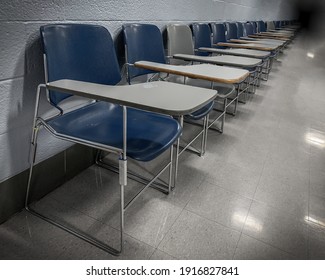 Moody, Angled Shot of a Row of School Chairs against a Wall, Extending to a Shadowy Background - Shutterstock ID 1916827841