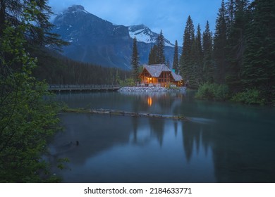 Moody, atmospheric golden light from traditional log cabin Emerald Lake Lodge at night in Rocky Mountains in Yoho National Park, BC, Canada. - Shutterstock ID 2184633771