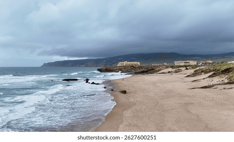 Moody beachscape with waves and dramatic clouds near Praia Grande, Sintra coast, Portugal