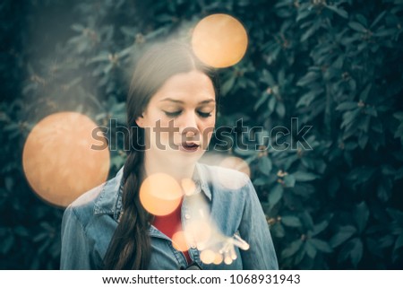 Moody and emotional portrait of a beautiful young woman, urban style, with fairy lights - Emotion, thoughts, inner depths concept