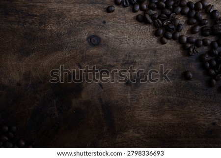 A moody flat lay background featuring roasted coffee beans arranged on a dark, textured chopping board, softly lit to create natural falloff and a refined atmosphere. The composition offers generous negative space for text, making it perfect for premium branding, editorial layouts, posters, menus, product packaging concepts, and sophisticated marketing designs. Rich textures and subtle lighting give this image a high‑end, cinematic feel while remaining versatile for commercial use.
