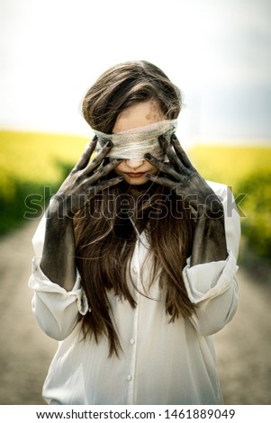 Similar – Junge Frau bedeckt ihr Gesicht vor der Sonne auf einem grünen Feld.