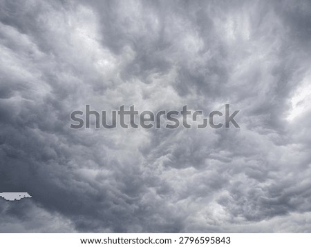 Moody grey storm cloud texture fills the frame, evoking uncertainty, tension, change, risk, and dramatic atmosphere.