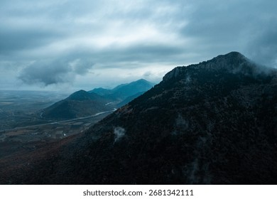 Moody mountain landscape with dramatic clouds and misty atmosphere