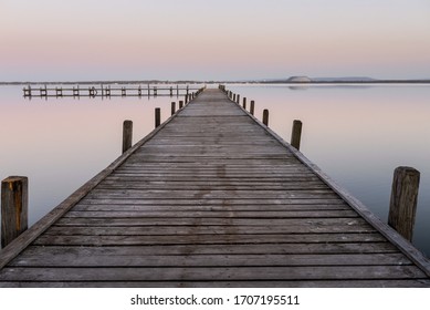 Moody pier on the lake with beautiful sunset