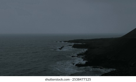 A moody seascape captures Iceland's rugged coastline under overcast skies. Perfect for projects seeking an atmospheric, minimalist aesthetic with a touch of solitude and raw natural beauty. - Powered by Shutterstock