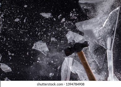 Moody, Shadowy High-Speed Photo Of A Ball-Peen Hammer Smashing Through A Sheet Of Ice - Exploding In A Cloud Of Dust And Shards With A Black Background