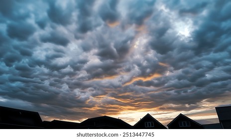 Moody sky with dramatic, textured clouds at sunset, silhouetted rooftops of houses in the foreground, capturing a captivating evening scene - Powered by Shutterstock - Get 15% off with code: PIKWIZARD15