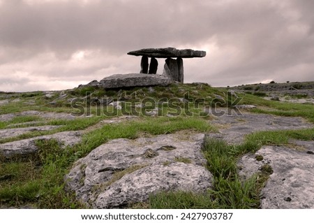 Moody sky over poulnabrone dolmen portal megalithic tomb at dusk, the burren, county clare, munster, republic of ireland (eire), europe