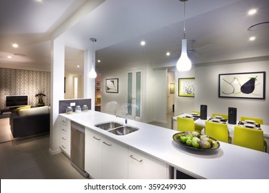 A Moody And Stylish Image Of A House With Kitchen And Attached Living Room And Food Placed On Kitchen Shelf