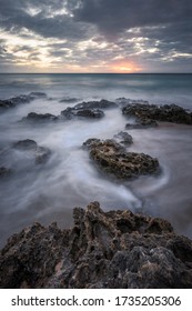 Moody Sunset Over Water Movements On Beach Rocks In Kenting, Taiwan