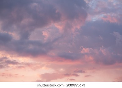 Moody sunset or sunrise sky with rays of light illuminating dark blue and bright and soft pink and orange clouds. no people, clouds only. High contrasts in a stormy sky - Shutterstock ID 2089995673