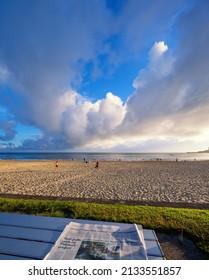 MOOLOOLABA, AUSTRALIA - Dec 24, 2021: A View From A Public Bench And Table Looking Over A Beach With A Newspaper Open On The Table