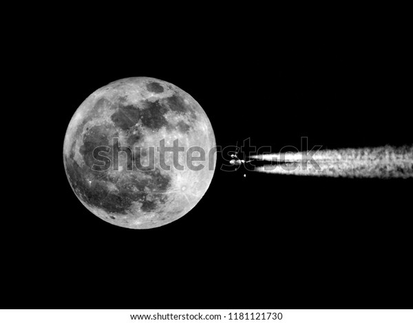 Moon and airplane\
contrails as background
