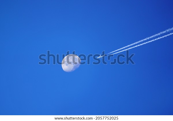 moon and airplane on\
the blue clear sky
