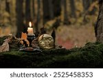 moon amulet and burning candle in forest, dark nature background. Samhain, Halloween. Witchcraft, esoteric spiritual ceremony. magic ritual. witch aesthetic. autumn equinox