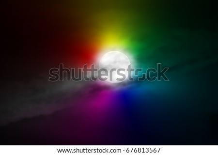 The moon appears in the night behind a cloud.