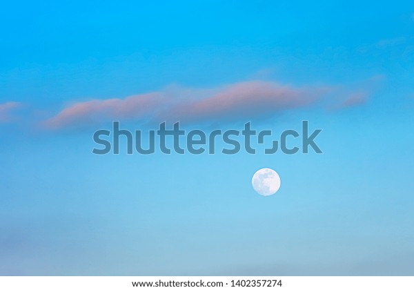 Moon in the blue day\
sky