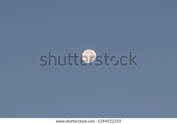 The Moon in the blue\
sky.