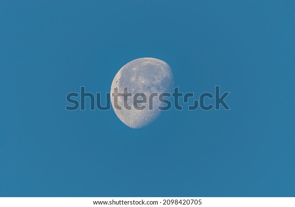 Moon in the blue sky\
background