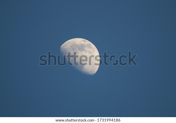 Moon in the blue sky. Crescent moon in front of\
the blue sky at sunset.