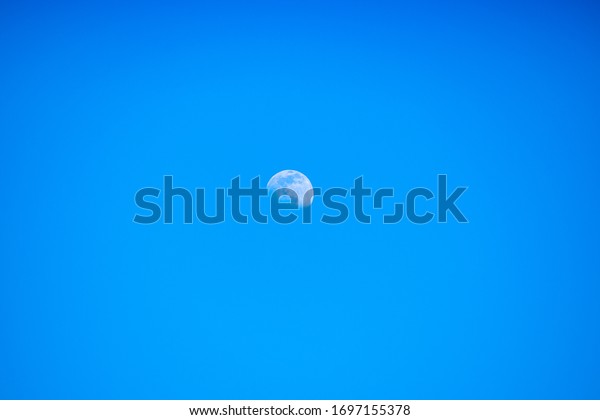 Moon
in the blue sky. Moon and blue sky during the
day.