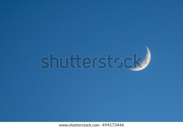 Moon in blue sky. Last light of the moon in a blue\
sky, copy space