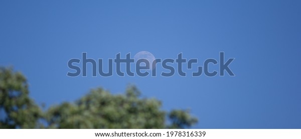 The moon in the blue sky, the rising moon in the\
evening sky