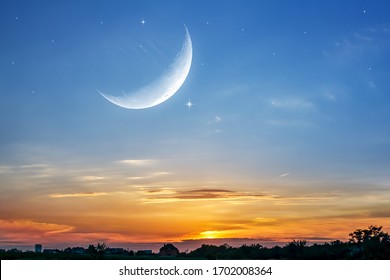 Moon in bright clouds of sunset sun . New moon , moon in the blue sky new moon in the clouds 