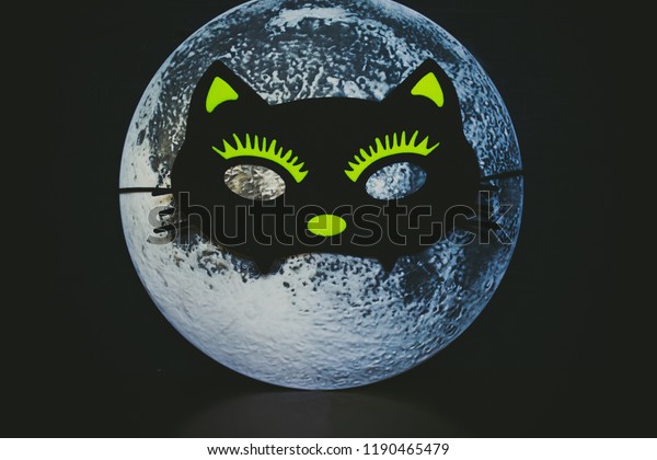 Moon in a cat mask. Night of Halloween. The moon\
wore a mask.