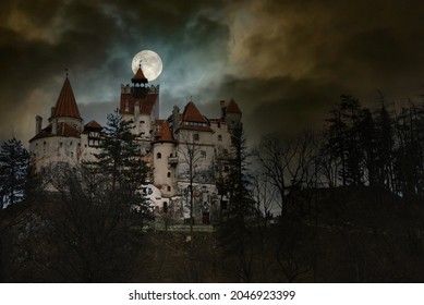 Moon in the clouds over Bran Castle, Transylvania, Romania. Medieval building, Dracula's Castle. Mystical night landscape.